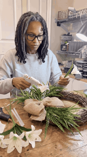 Gluing white lilies into the wreath
